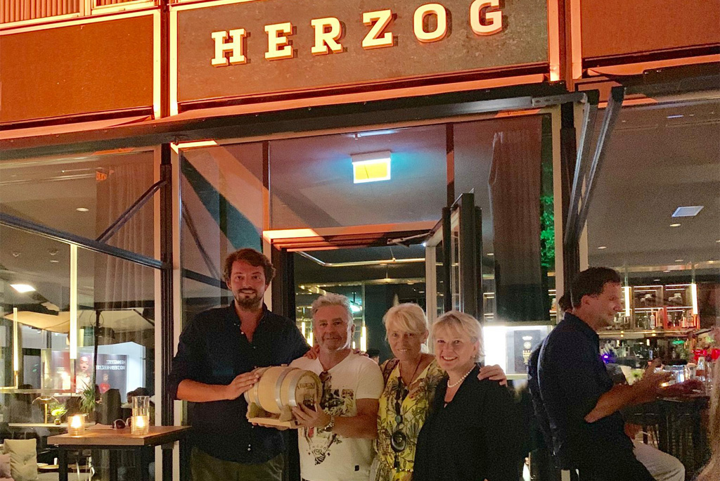Familie Ketzer mit Fässchen und Frau Borgolte vor der Bar Herzog