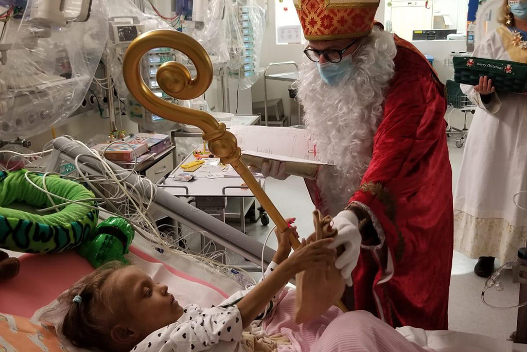 Weihnachtsmann bei Mädchen am Krankenbett